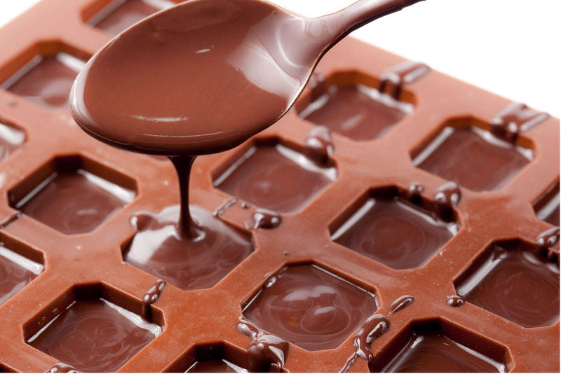 pouring melted chocolate into square molds